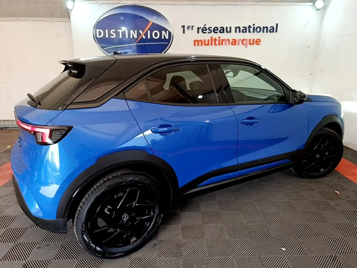 Opel Mokka 2024 bleu vue de profil droit, toit noir, jantes noires et feux arrière LED visibles.