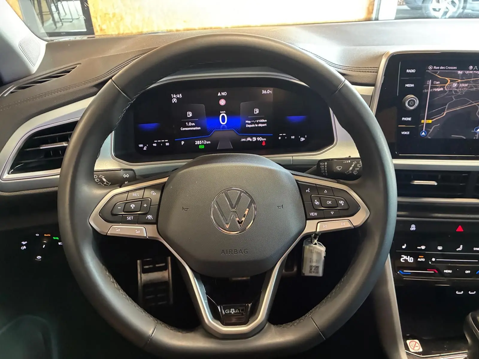 Vue centrée sur le volant du Volkswagen T-Roc 2025, tableau de bord numérique et écran tactile de navigation visibles.