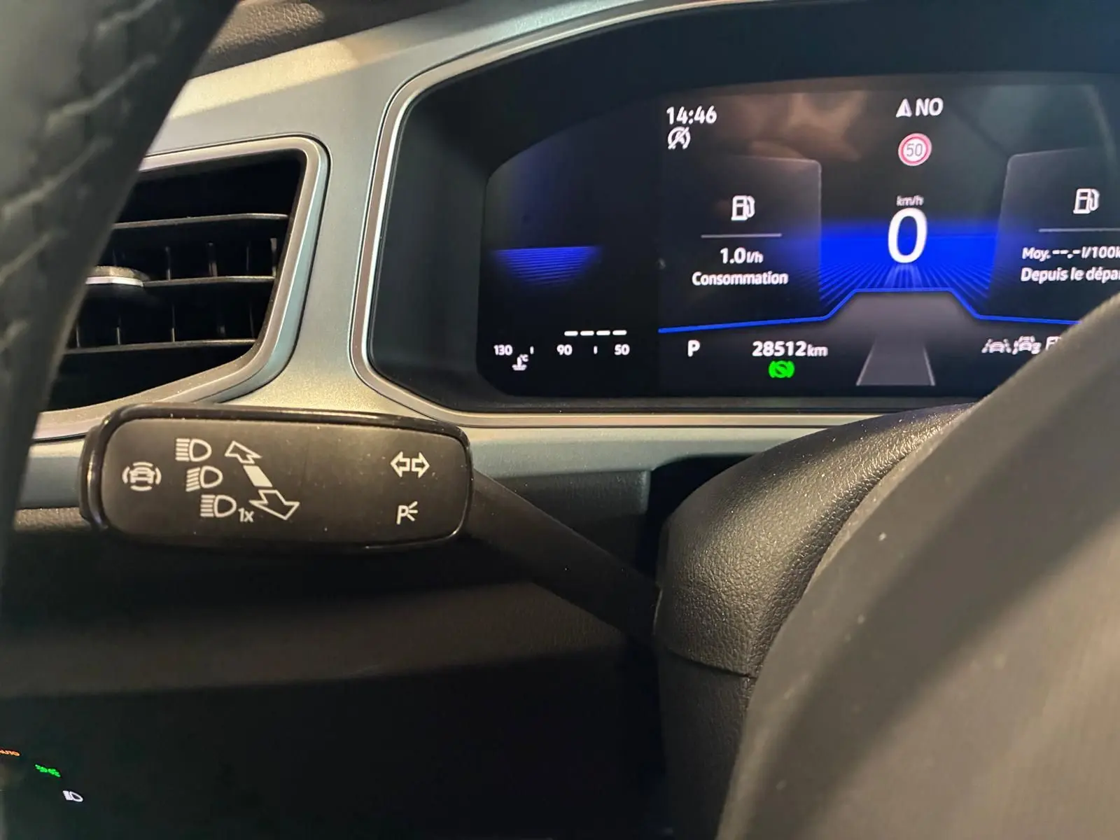 Vue rapprochée du tableau de bord numérique et du commodo gauche du Volkswagen T-Roc 2025, affichage digital clair.