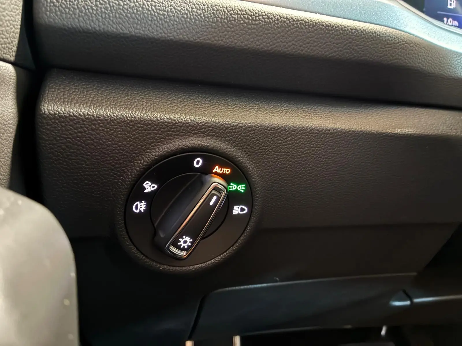 Gros plan sur le bouton de commande des phares du Volkswagen T-Roc 2025, avec réglage sur mode automatique.