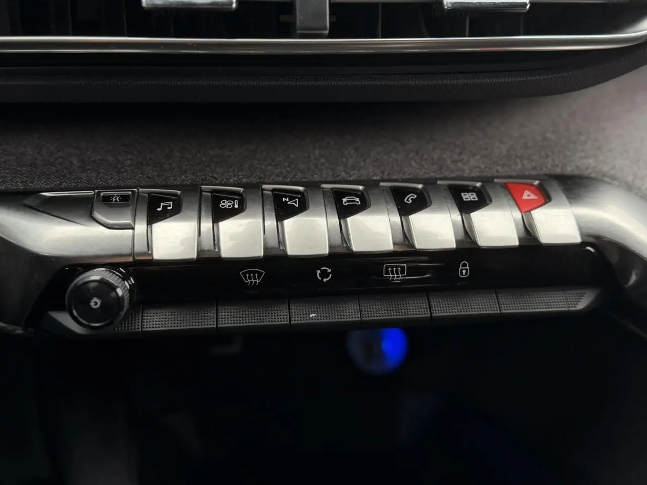 Gros plan sur les commandes centrales métalliques et noires du tableau de bord du Peugeot 5008 GT Line bleu foncé.