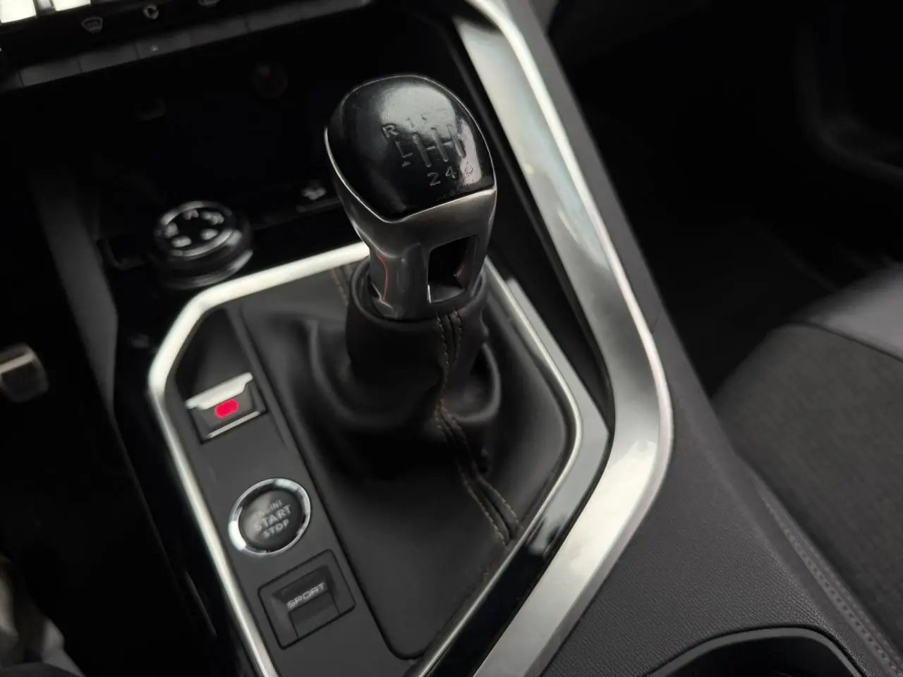 Gros plan sur le levier de vitesses manuel noir du Peugeot 5008 GT Line, entouré de commandes et console noire.