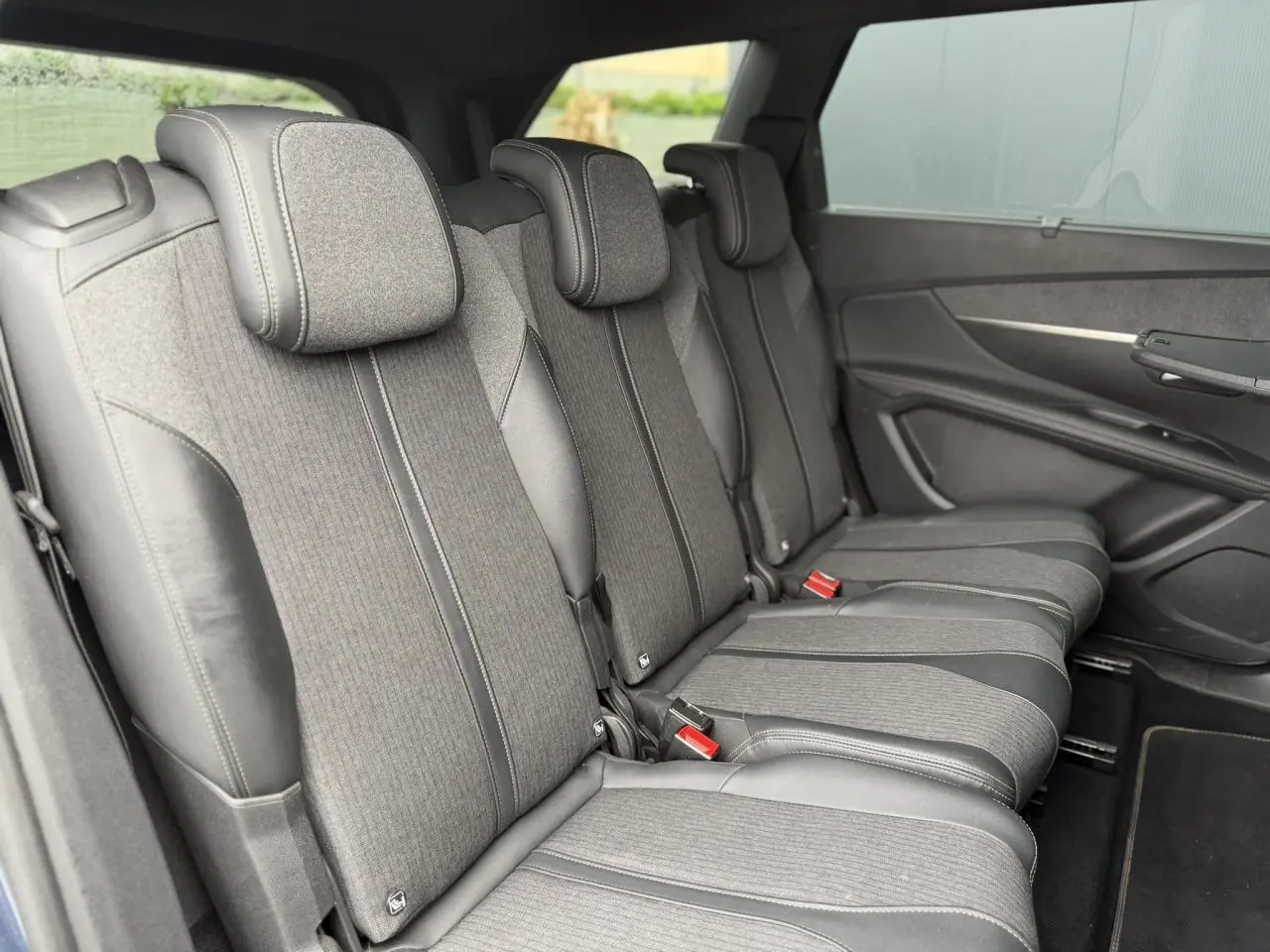 Vue latérale des trois sièges arrière indépendants en tissu et cuir noir du Peugeot 5008 GT Line 2019.