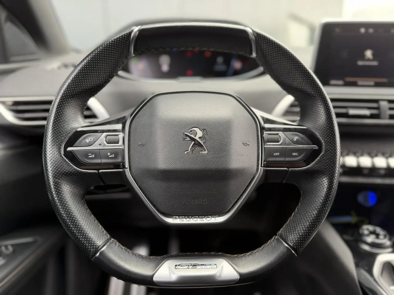Gros plan sur le volant cuir perforé du Peugeot 5008 GT Line 2019 avec commandes intégrées et badge GT Line.