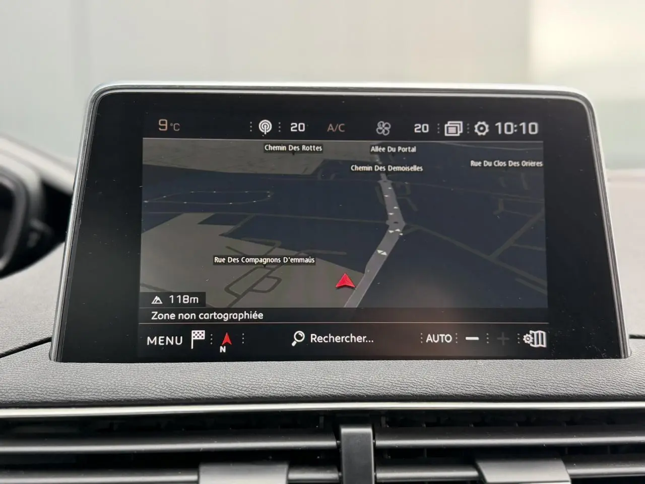 Écran tactile du système de navigation Peugeot i-Cockpit affichant une carte en intérieur du 5008 bleu foncé.