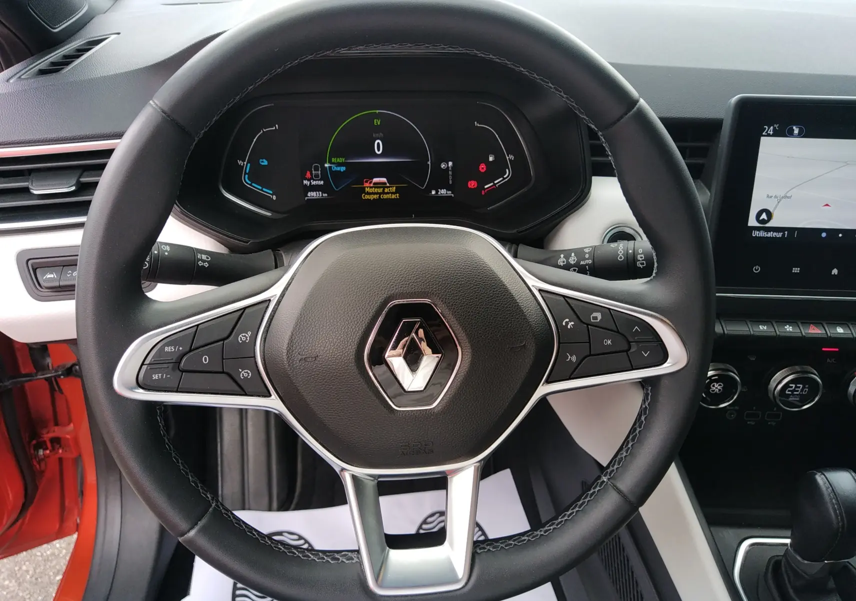 Vue rapprochée du volant noir de la Renault Clio V E-TECH 140ch 21N INTENS avec tableau de bord digital et écran central.