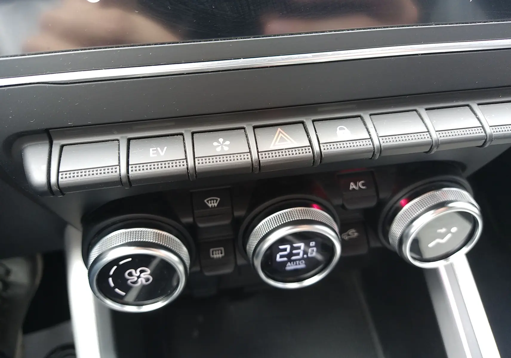 Gros plan sur la console centrale de la Renault Clio V E-TECH 140ch 21N Intens, montrant les commandes de climatisation digitales.