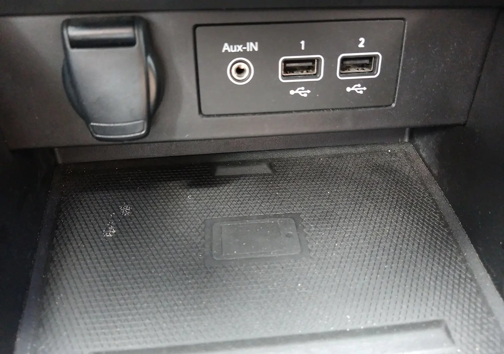 Gros plan sur les ports USB et prise Aux-IN dans l’habitacle noir de la Renault Clio V E-TECH 2022, zone de recharge sans fil visible.