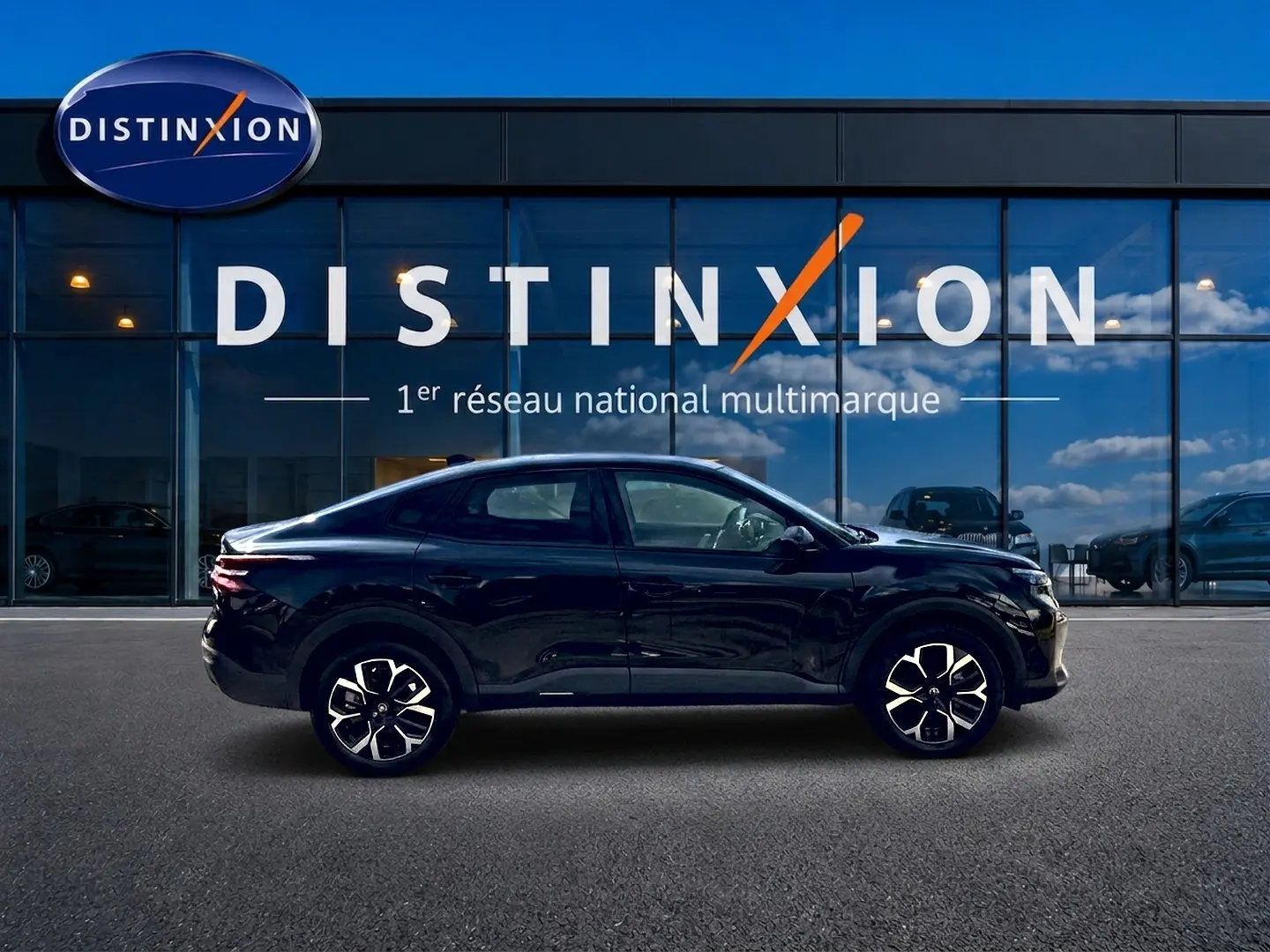 Citroën C4 X noire vue de profil côté gauche, avec jantes alu et silhouette élégante devant une vitrine Distinxion.