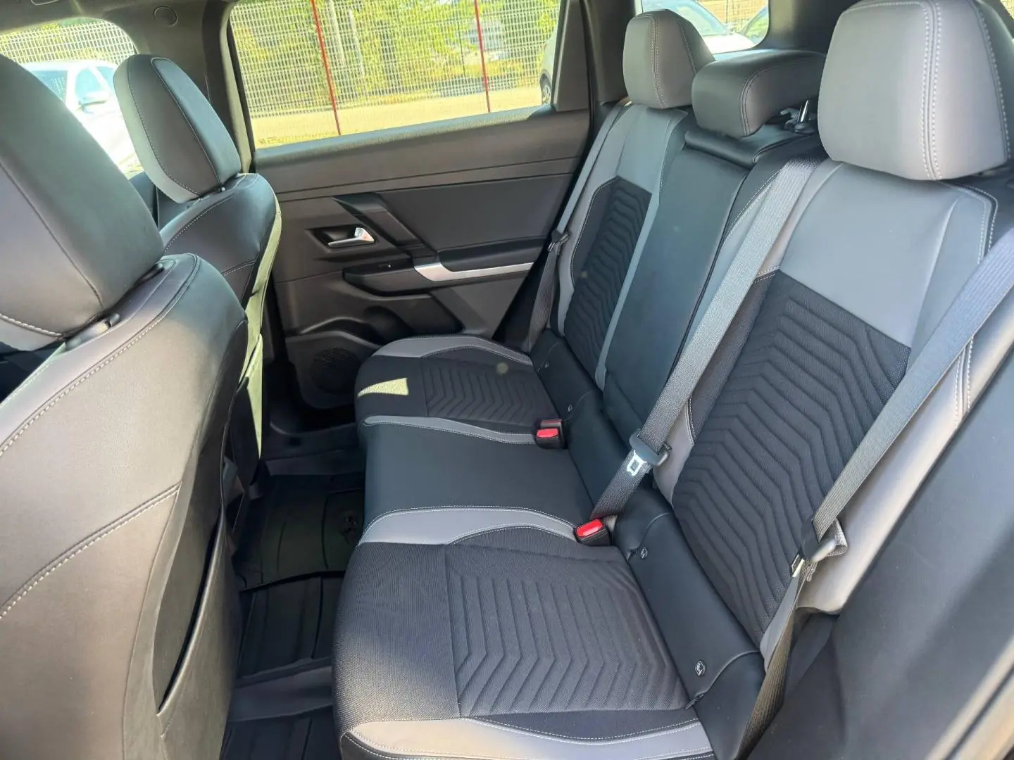 Vue intérieure côté droit sur la banquette arrière noire et grise du Jeep Compass Yosemite 2026 avec ceintures de sécurité visibles.