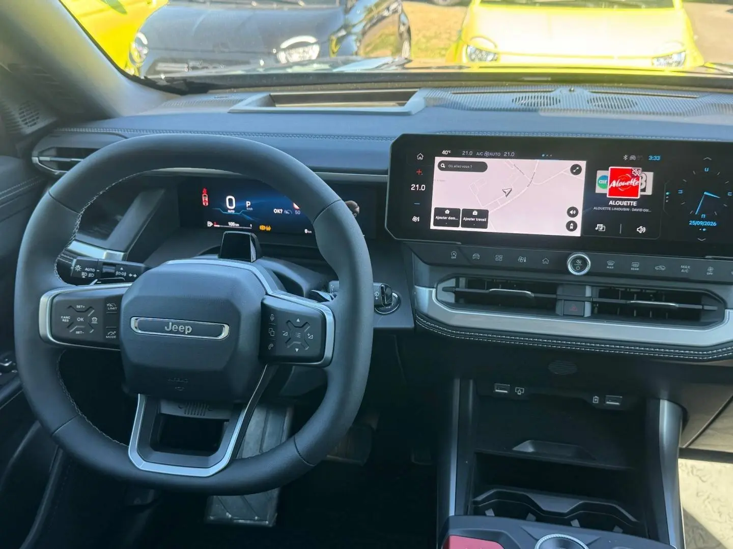 Vue intérieure du tableau de bord du Jeep Compass 2026, avec volant multifonctions et grand écran tactile central.