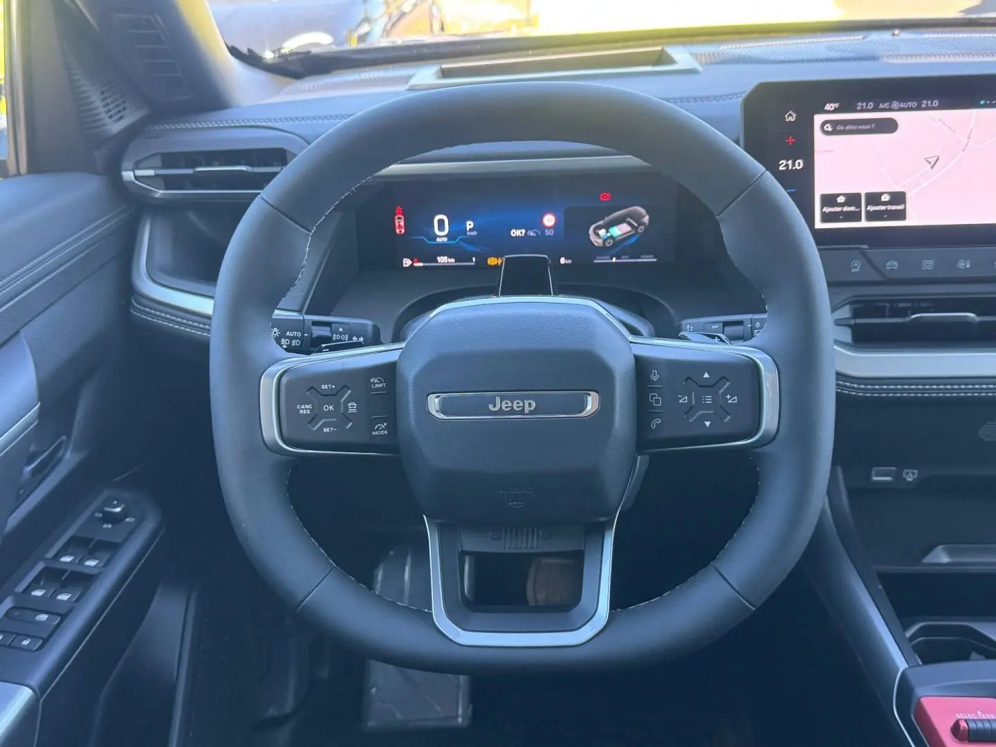 Vue frontale du volant noir du Jeep Compass 2026 avec tableau de bord numérique et écran tactile latéral.