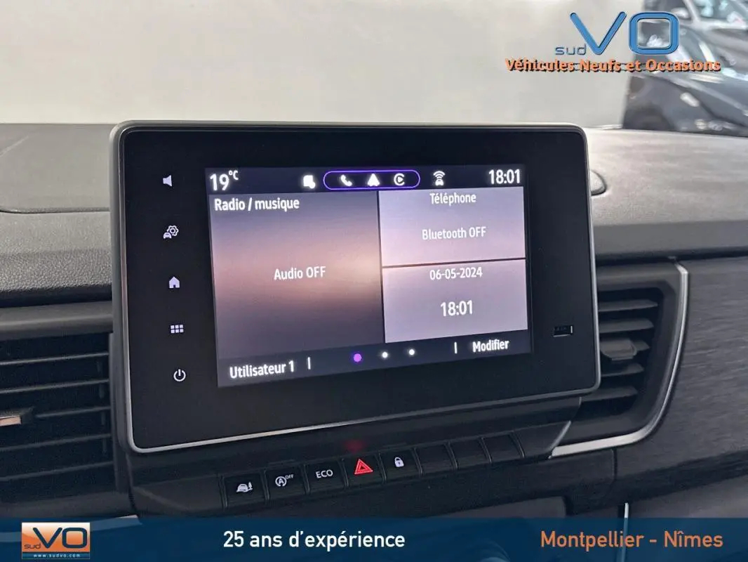 Écran tactile central du tableau de bord du Renault Trafic Fourgon gris, affichant les options audio et téléphone.