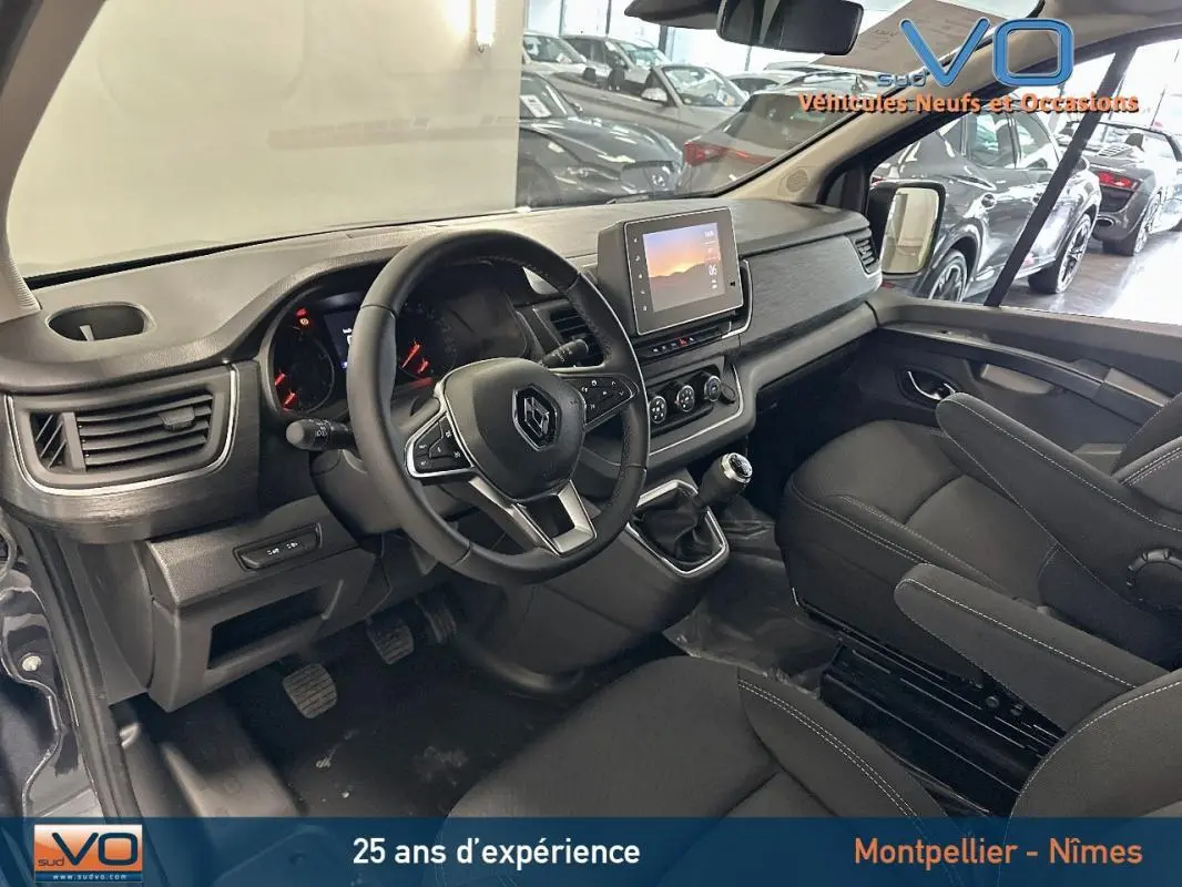 Intérieur du Renault Trafic Fourgon gris 2025, vue côté conducteur sur tableau de bord et volant multifonction.