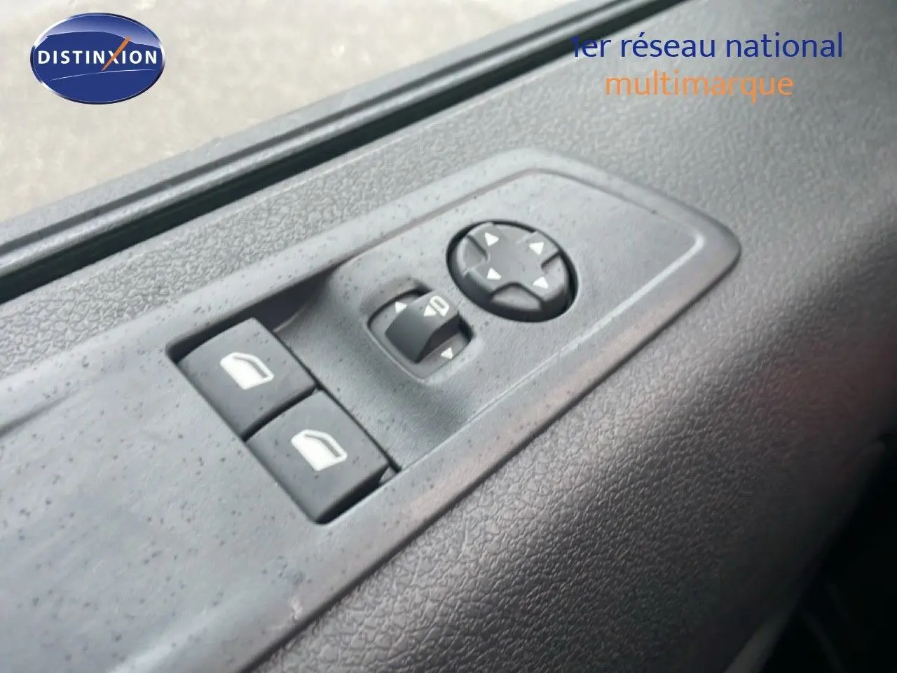Gros plan sur les commandes de réglage des rétroviseurs et vitres côté conducteur du Citroën Jumpy gris titane.