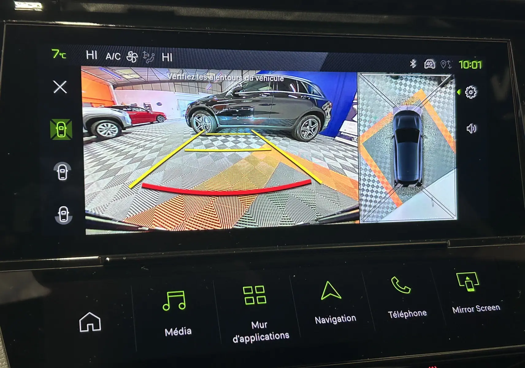 Écran de caméra 360° montrant un SUV noir en vue latérale droite dans un garage avec marquages au sol colorés.