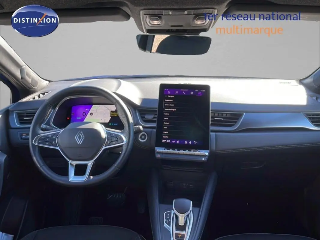 Vue intérieure frontale du tableau de bord de la Renault Symbioz 2025 avec écran tactile vertical et volant multifonctions cuir.