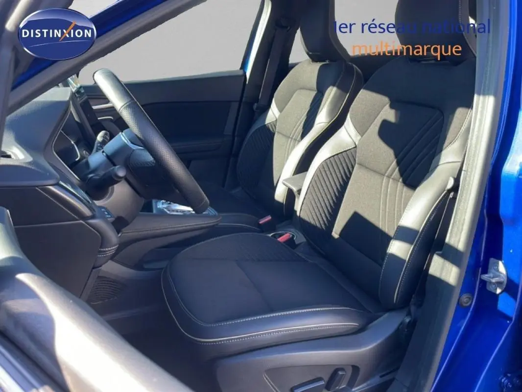 Vue intérieure côté gauche du Renault Symbioz bleu 2025, mettant en valeur les sièges avant noirs et le volant multifonctions.