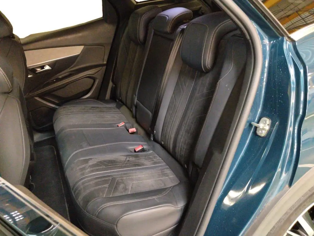 Vue intérieure côté droit montrant la banquette arrière en cuir noir du Peugeot 3008 Hybrid 225 e-EAT8 GT Pack bleu clair.