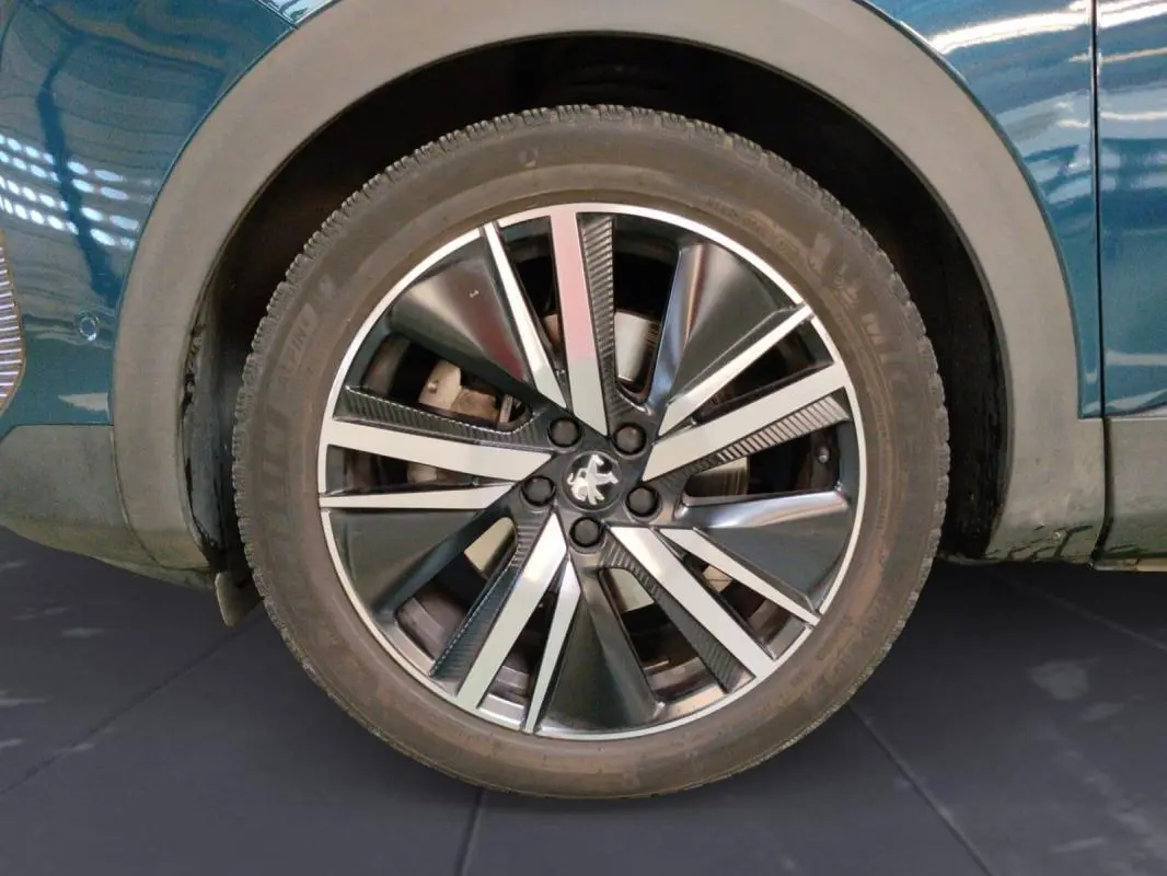 Gros plan sur la roue avant droite du Peugeot 3008 Hybrid 225 e-EAT8 GT Pack bleu clair avec jante alliage 19 pouces.