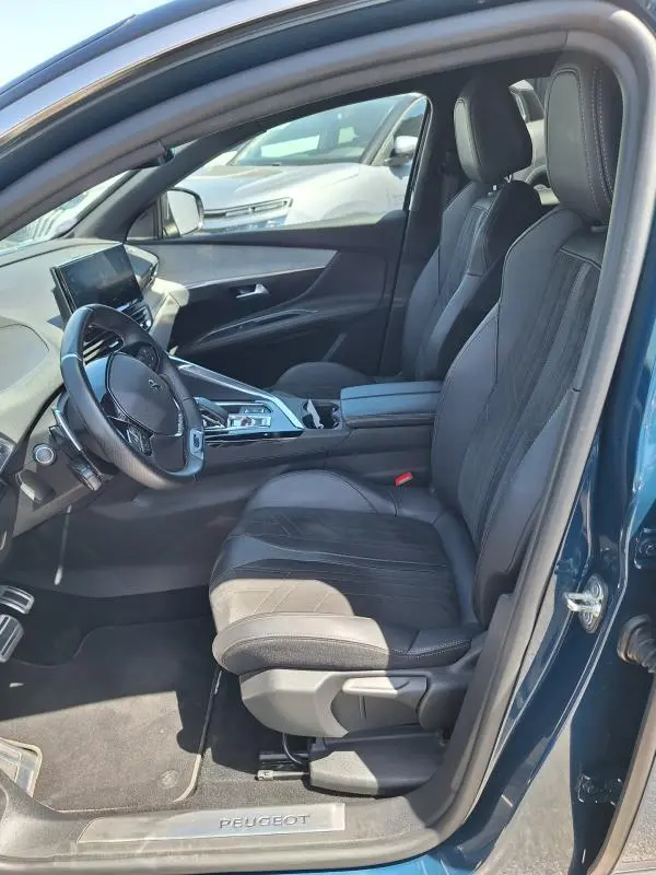 Intérieur avant droit du Peugeot 3008 Hybrid 225 GT Pack bleu clair, sièges cuir noirs et écran tactile visible.