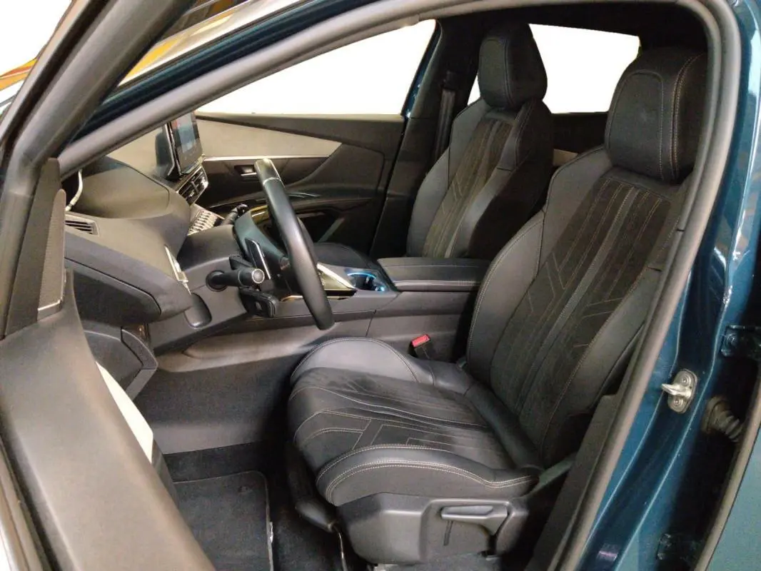 Vue intérieure côté conducteur du Peugeot 3008 Hybrid 225 e-EAT8 GT Pack bleu clair, montrant les sièges en cuir et le tableau de bord moderne.