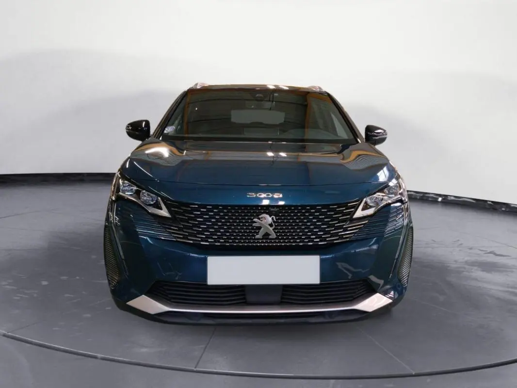 Vue frontale d'un Peugeot 3008 Hybrid 225 e-EAT8 GT Pack bleu foncé avec calandre distinctive et phares LED anguleux.
