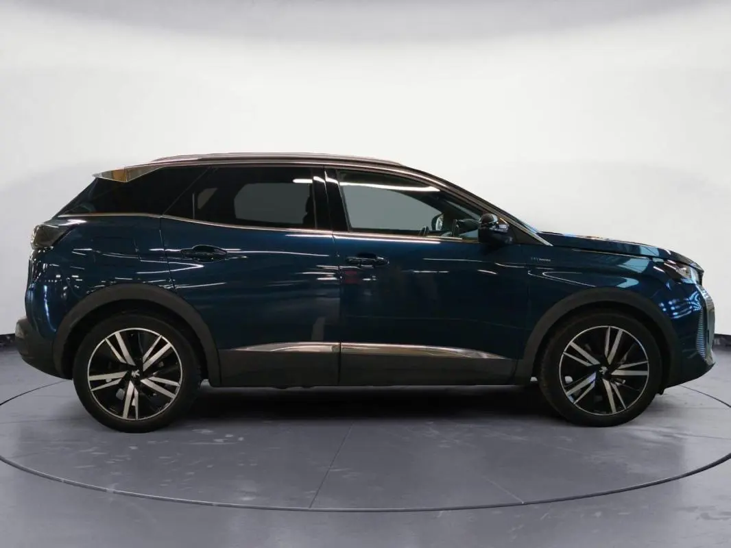 Vue de profil droit du Peugeot 3008 Hybrid 225 e-EAT8 GT Pack bleu foncé avec jantes alliage noires et toit noir.