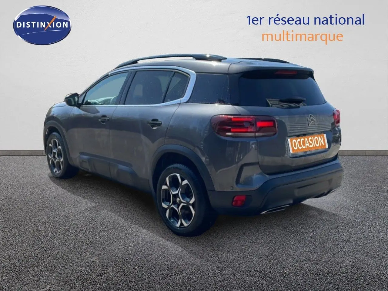 Vue 3/4 arrière droite d'un Citroën C5 Aircross gris platinium métallisé avec jantes bi-ton et toit noir.