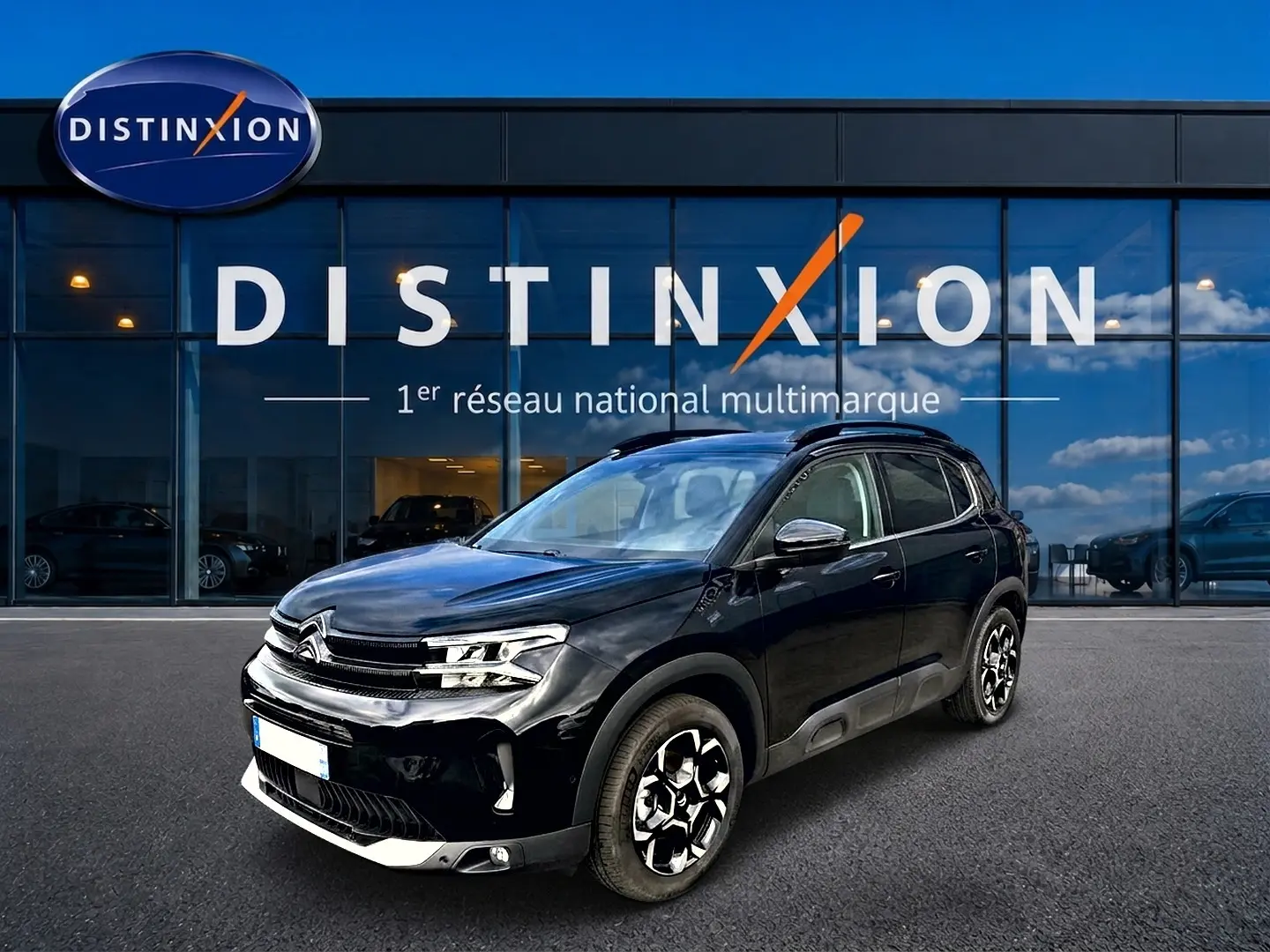 Citroën C5 Aircross noir vue 3/4 avant droit, avec jantes alu distinctives et barres de toit visibles.