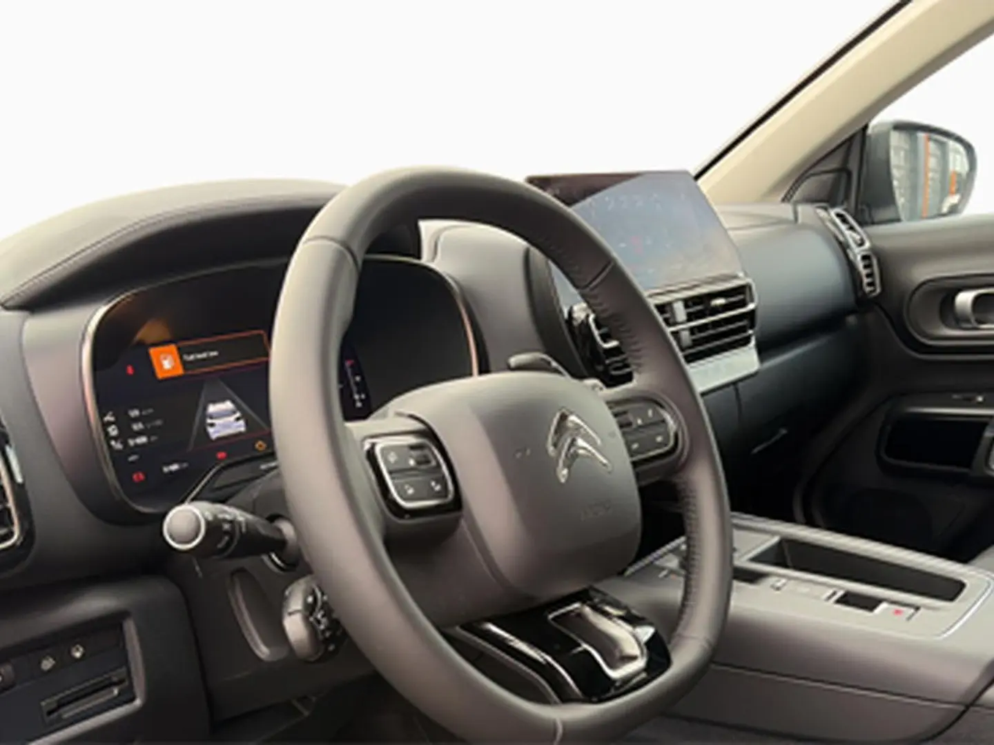 Vue intérieure du poste de conduite du Citroën C5 Aircross 2025, volant cuir noir et écran tactile central.