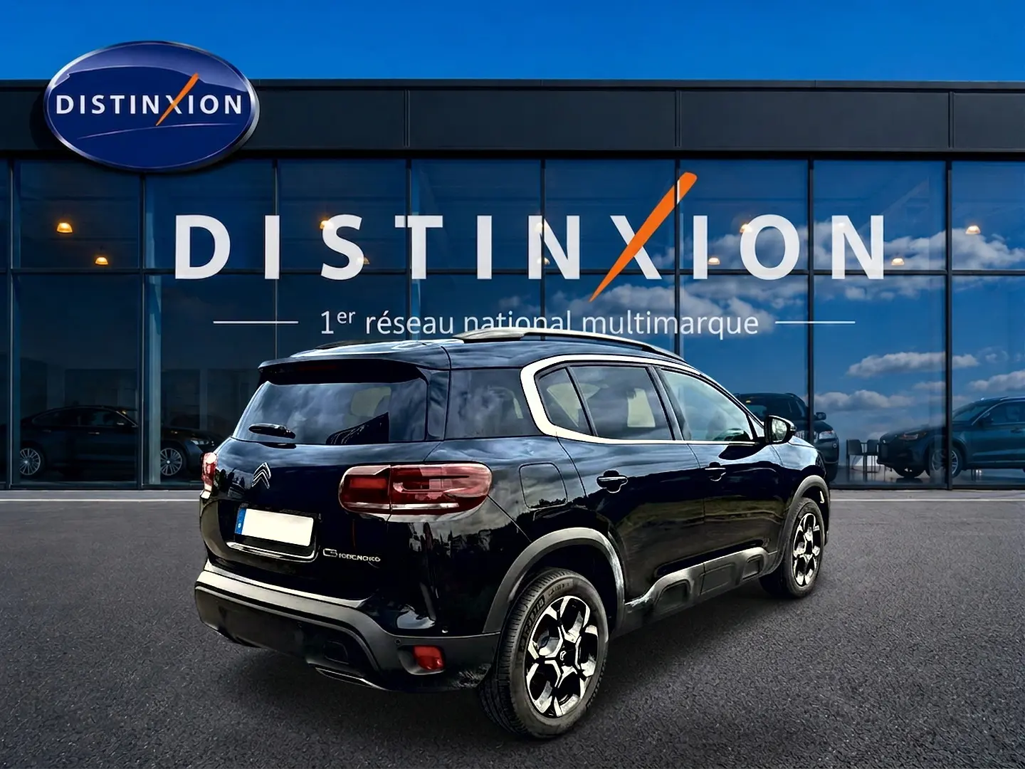 Citroën C5 Aircross noir vue 3/4 arrière droit, avec jantes alu et vitres arrière teintées devant showroom Distinxion.