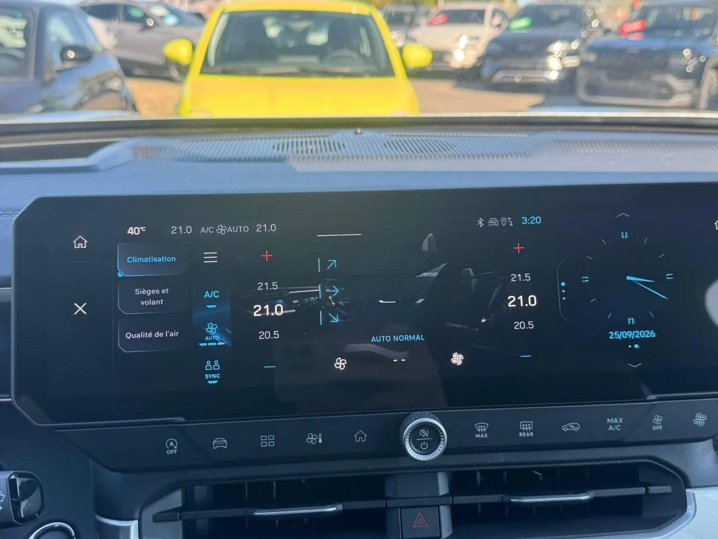 Vue rapprochée de l'écran tactile multifonction du tableau de bord du Jeep Compass 2026 avec commandes climatisation et horloge digitale.