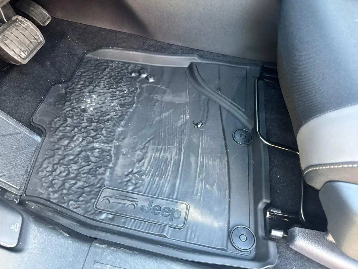 Gros plan sur le tapis de sol noir marqué Jeep, côté conducteur du Jeep Compass Yosemite 2026, intérieur avant.