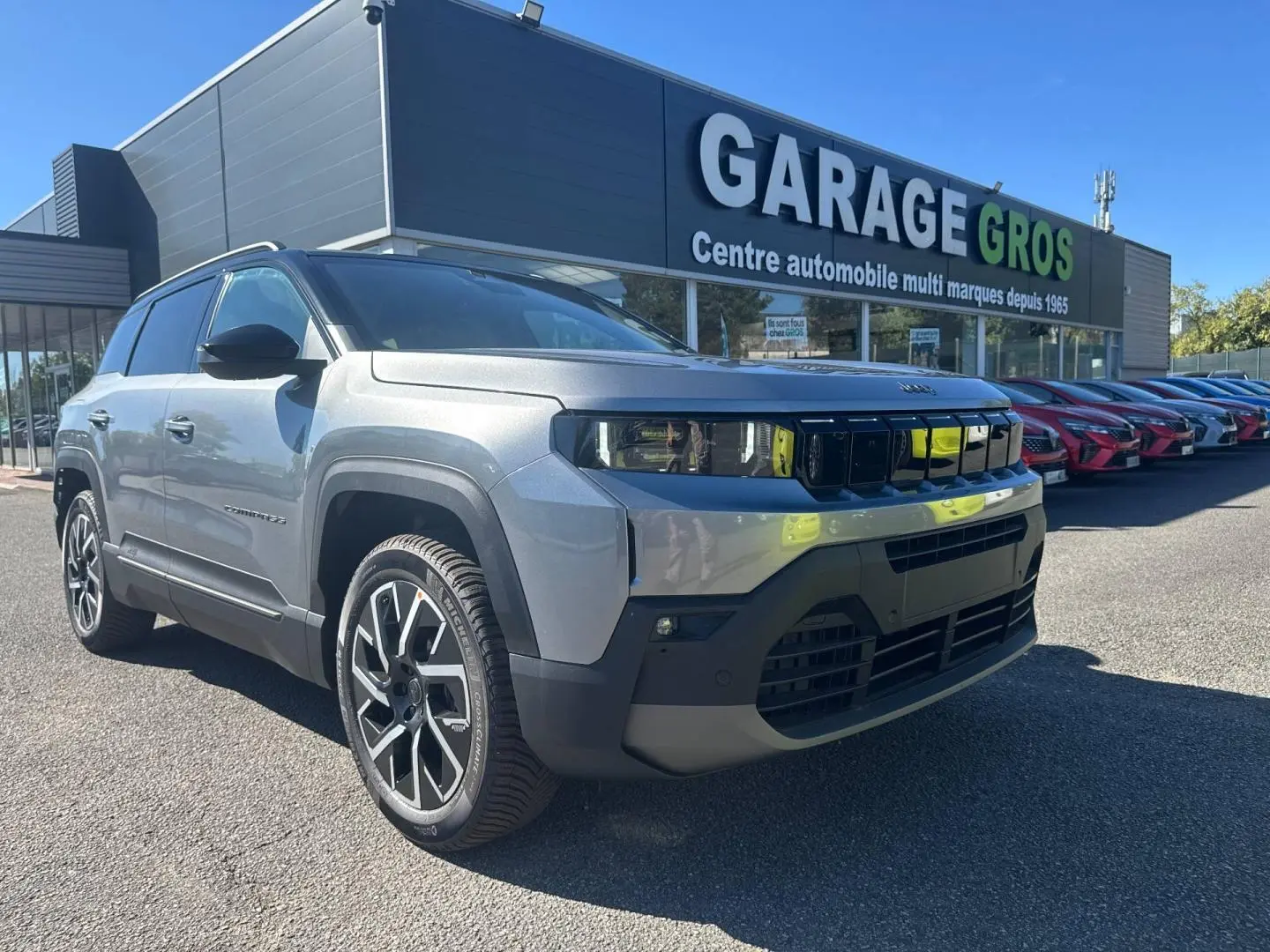 Jeep Compass 2026 Yosemite avec toit noir, vue 3/4 avant droit, garé devant un garage automobile.