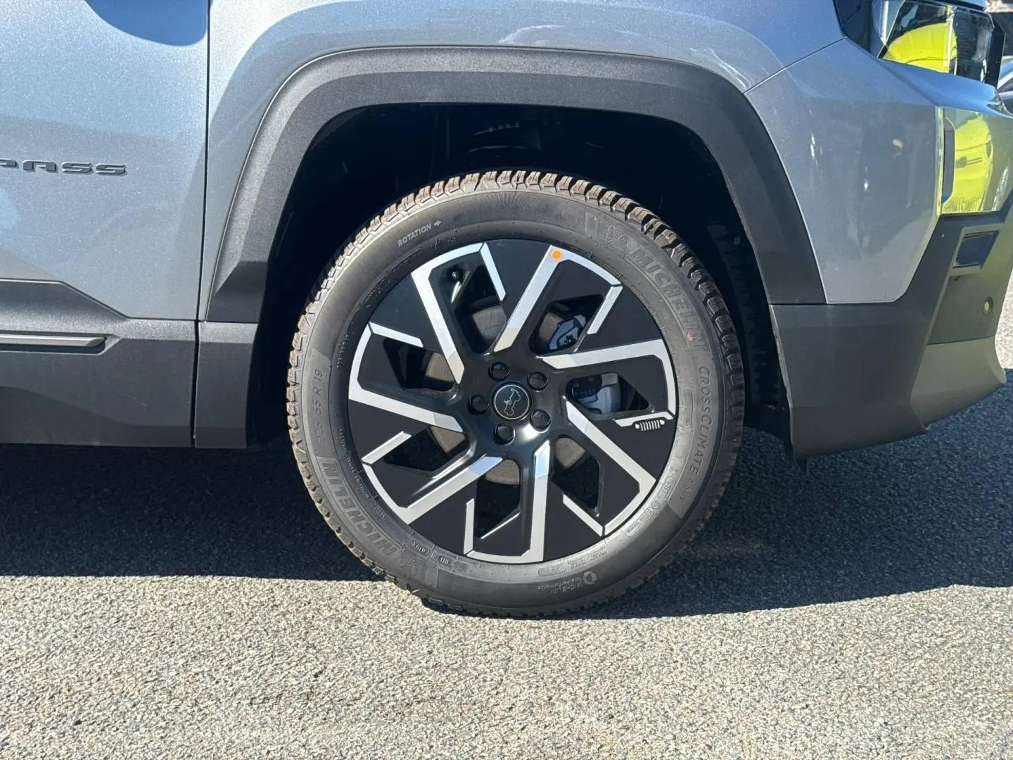 Gros plan sur la roue avant droite du Jeep Compass Yosemite gris avec jante alu noire et argentée.