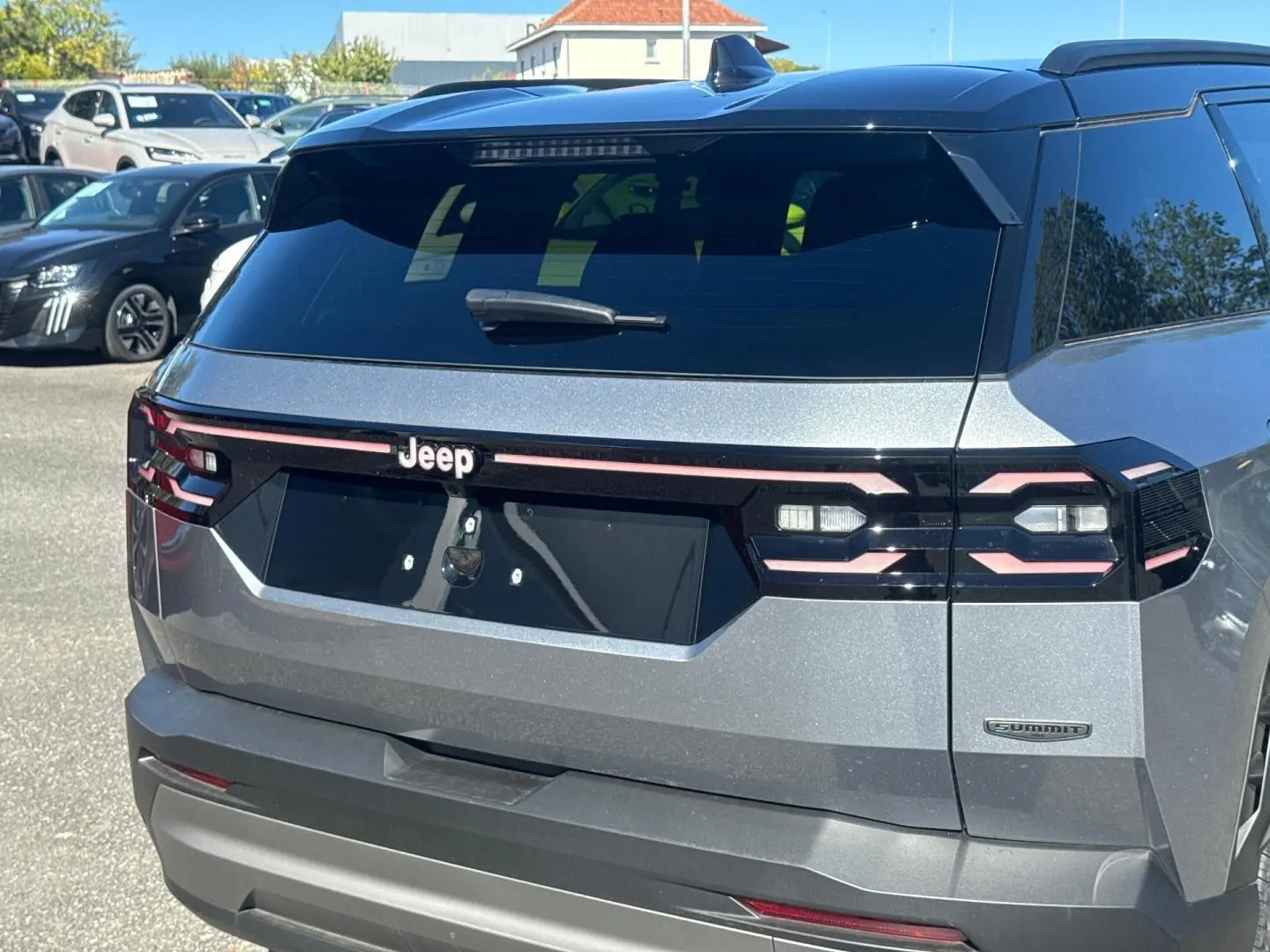 Vue arrière droite du Jeep Compass 2026 Yosemite avec toit noir, feux arrière LED et badge Summit visible.