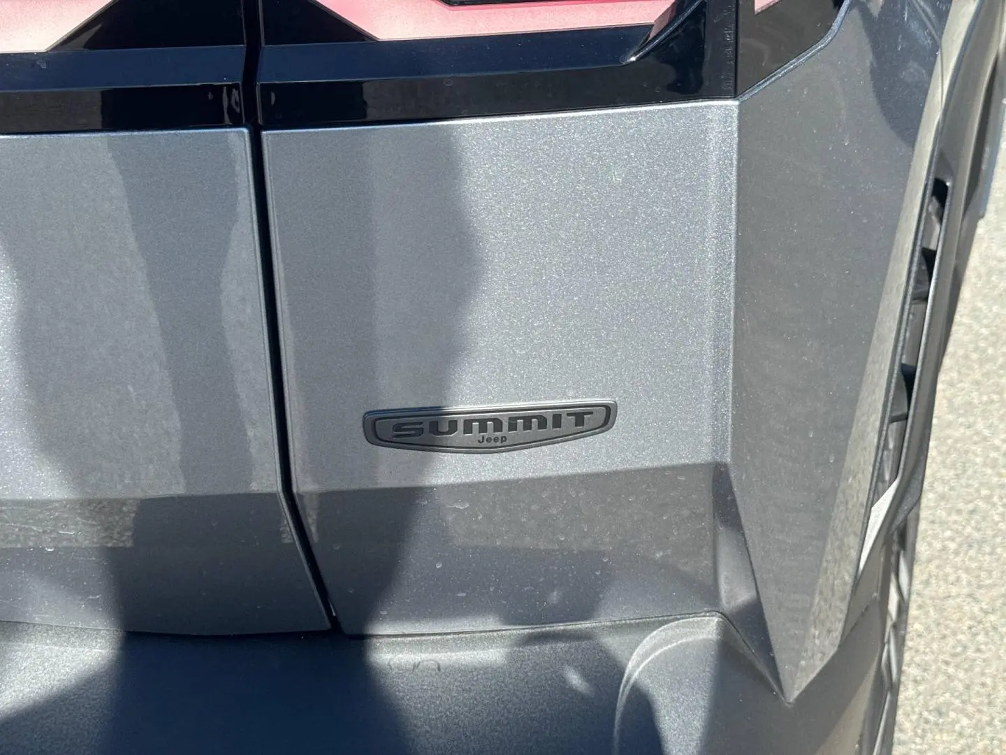 Gros plan sur l’écusson Summit noir sur la portière côté droit d’un Jeep Compass Yosemite gris métallisé.