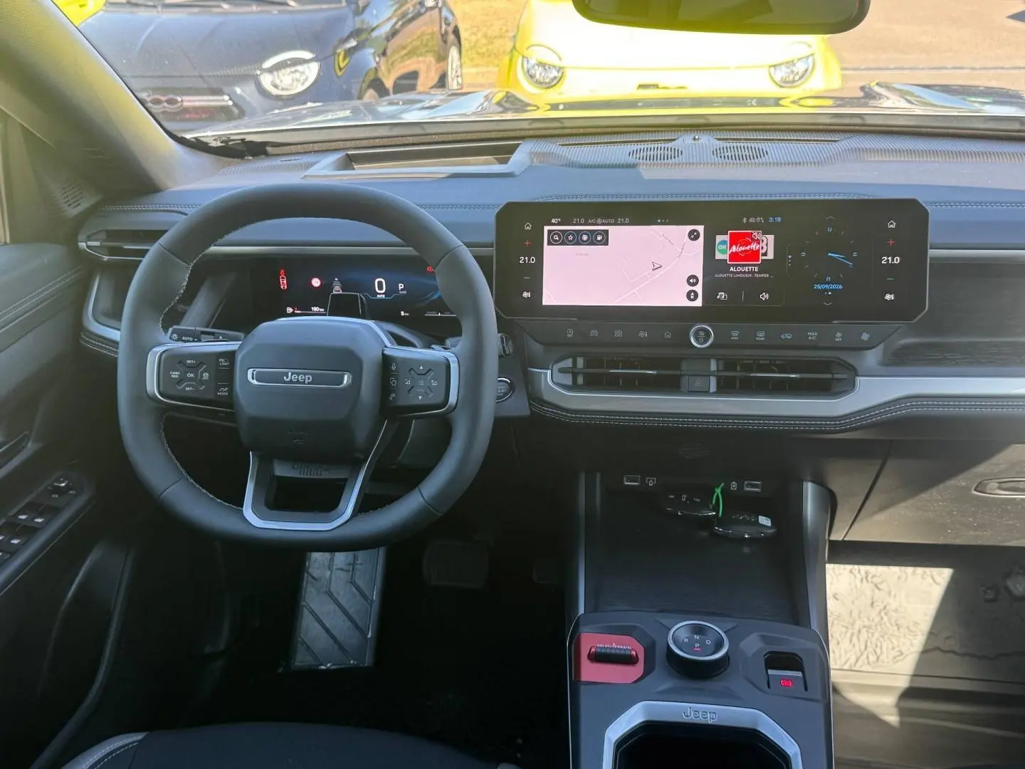 Vue intérieure frontale du Jeep Compass 2026, tableau de bord noir avec écran tactile large et volant multifonctions.