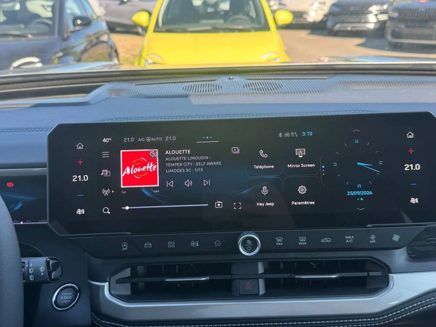 Vue intérieure du tableau de bord du Jeep Compass 2026 avec écran tactile large affichant radio et commandes climatisation.