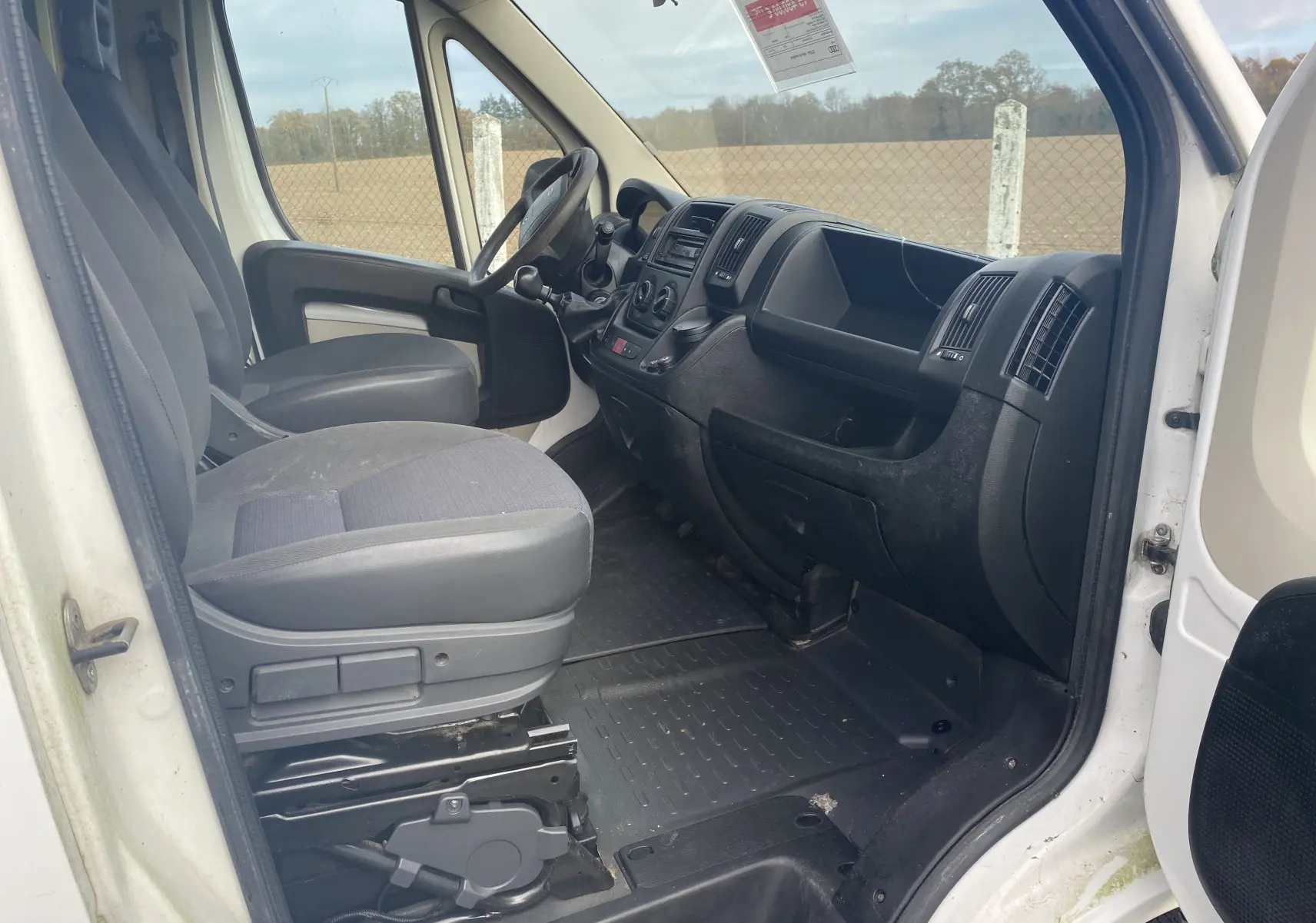 Intérieur côté conducteur du Citroën Jumper L3H2 blanc 2011, montrant les sièges et tableau de bord noir simple.