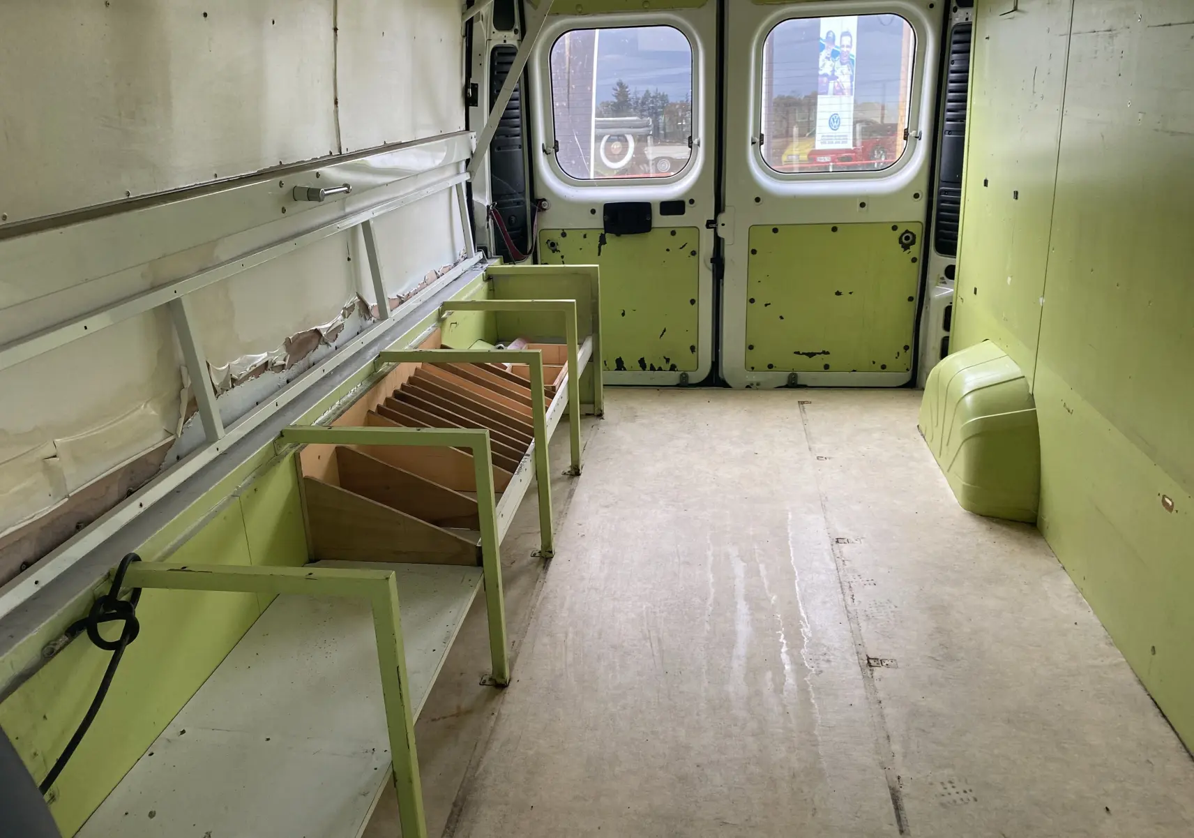 Intérieur du Citroën Jumper L3H2 2011 vu de l'avant vers les portes arrière, avec aménagements verts usés sur les côtés.