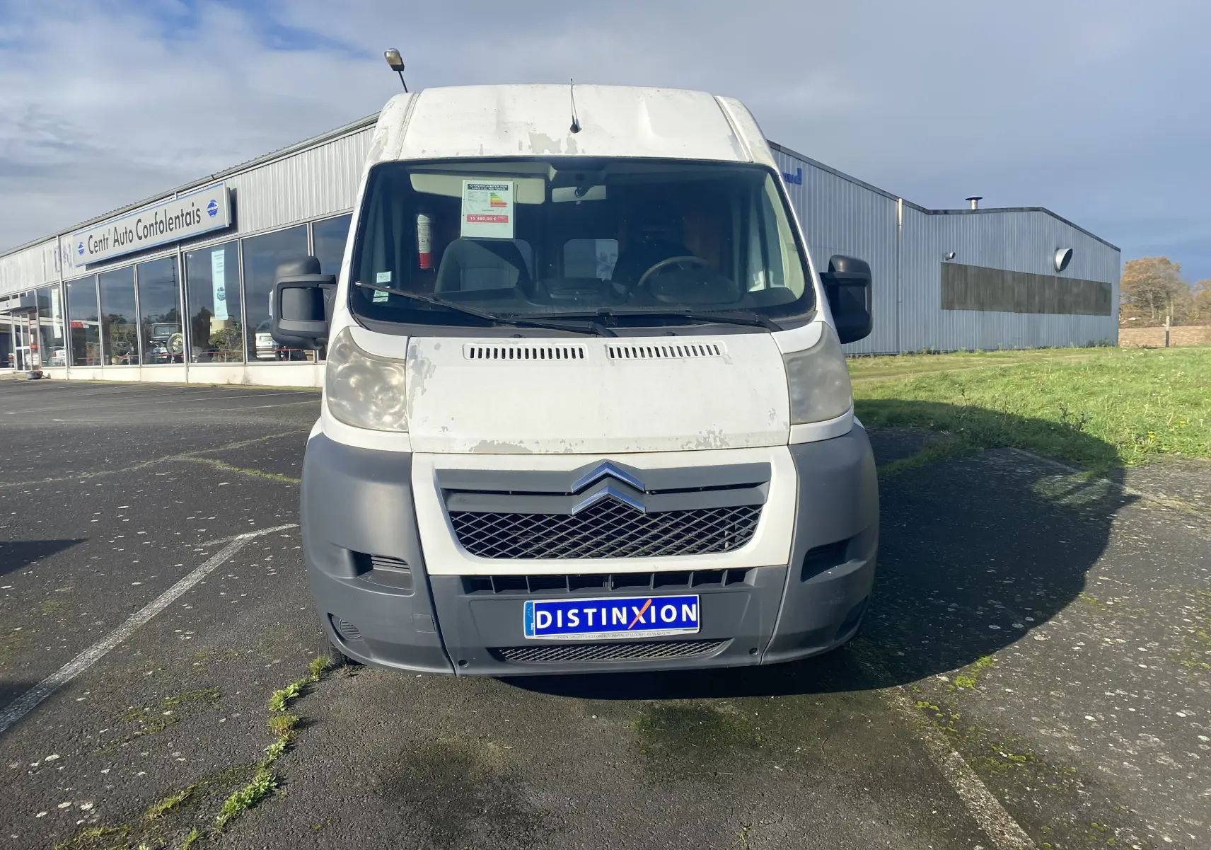 Vue de face d’un utilitaire Citroën Jumper blanc 2011 avec calandre noire et pare-chocs gris, stationné devant un bâtiment.