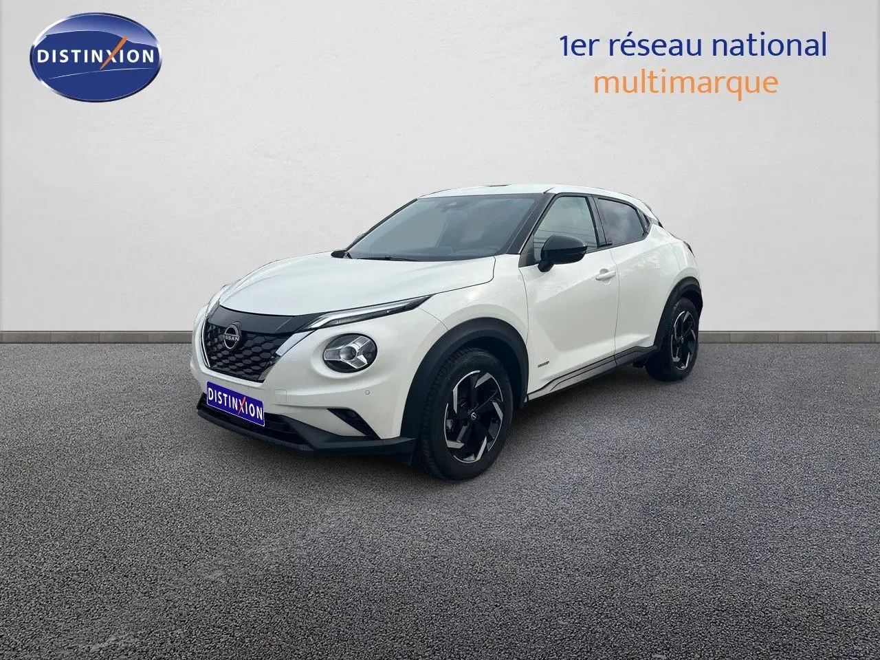 Nissan Juke blanc nacré métal vu en 3/4 avant droit, avec jantes noires et détails noirs contrastants.