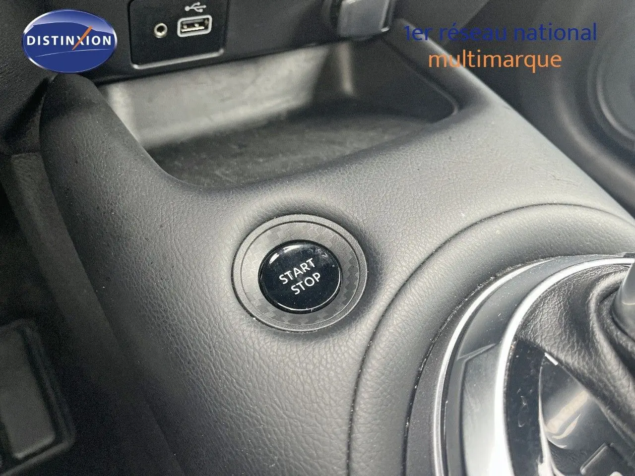 Bouton start/stop en gros plan sur la console centrale noire du Nissan Juke blanc nacré 2024 hybride.