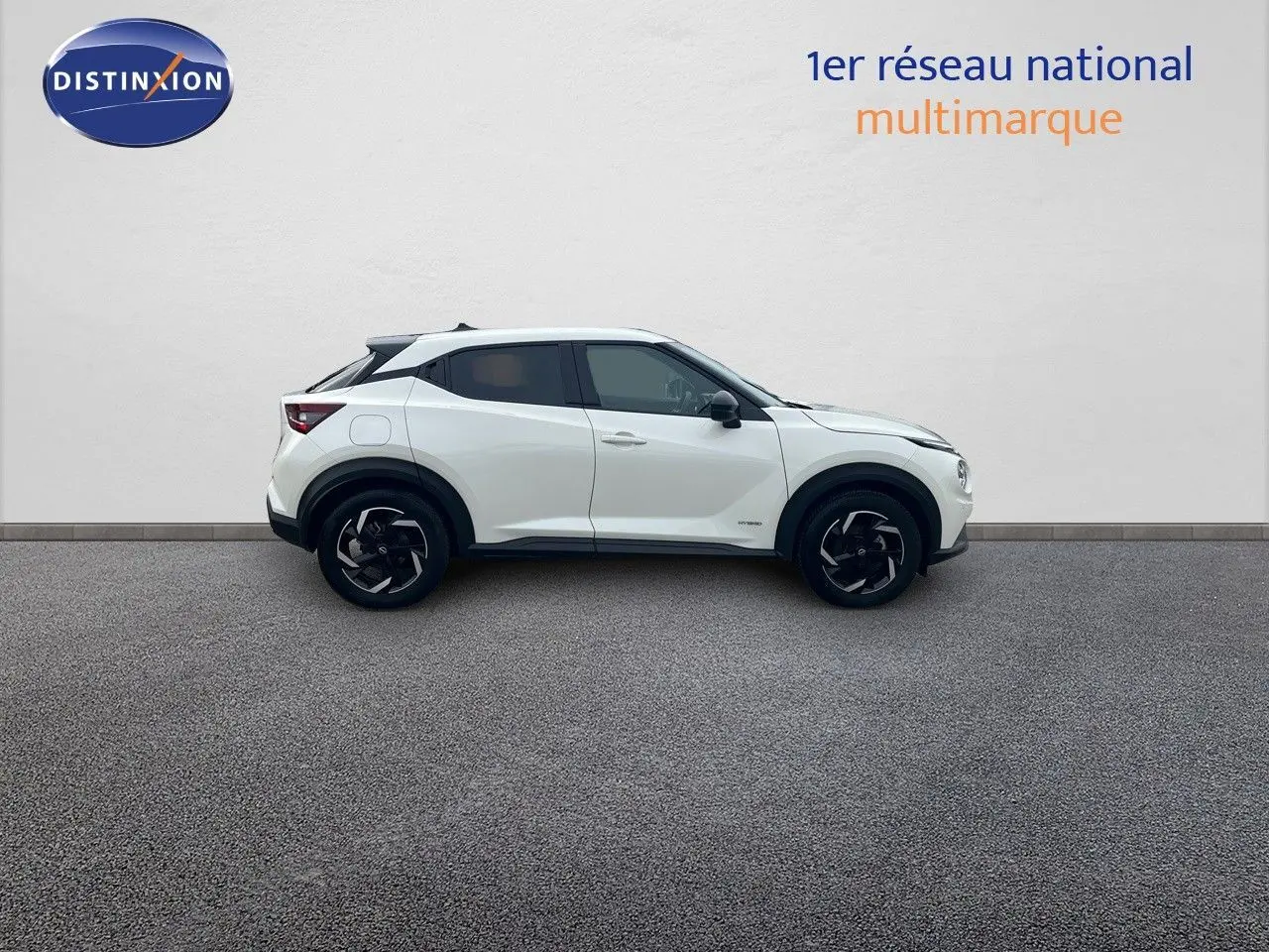 Profil droit d'un Nissan Juke blanc nacré 2024, finition N-Connecta avec jantes noires bicolores.