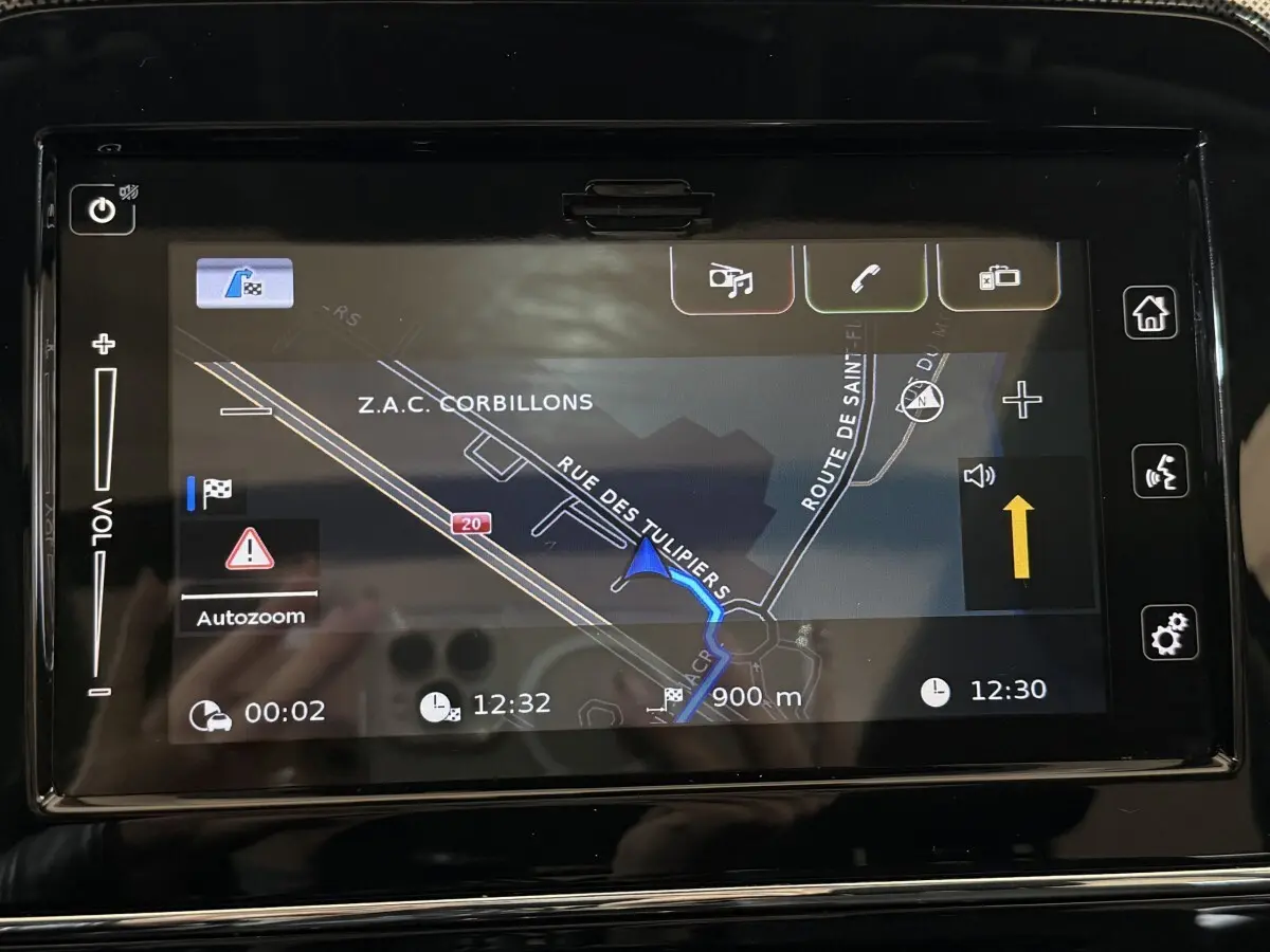Écran tactile de navigation du Suzuki Vitara 1.5 Dualjet hybrid STYLE 2022, affichage clair avec carte et itinéraire visible.