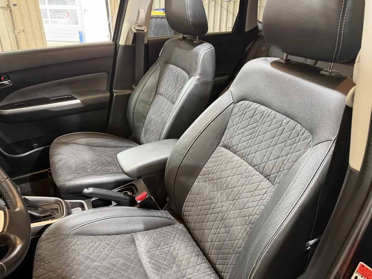 Vue intérieure rapprochée des sièges avant noirs en cuir et tissu du Suzuki Vitara 1.5 Dualjet hybrid STYLE 2022.