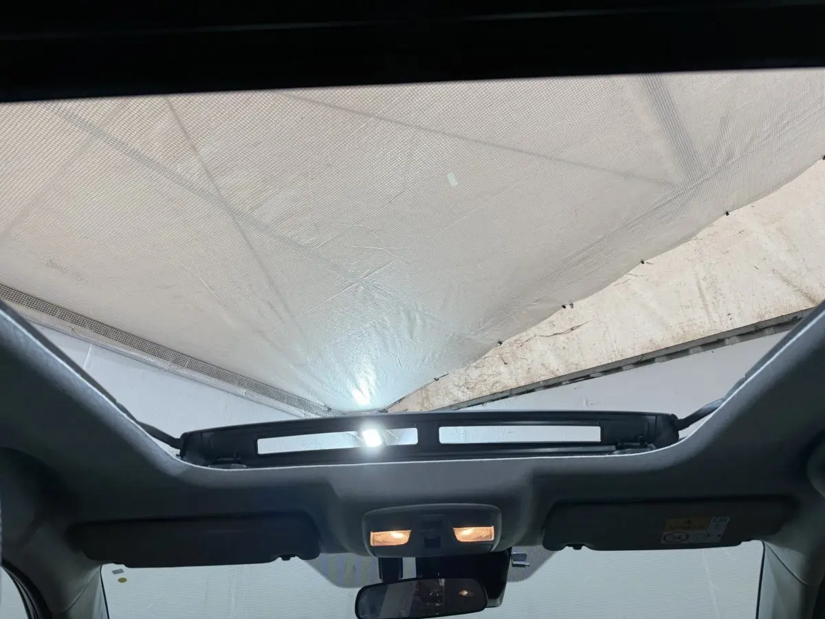 Toit ouvrant panoramique électrique ouvert vu de l'intérieur avant du Suzuki Vitara noir 2022.