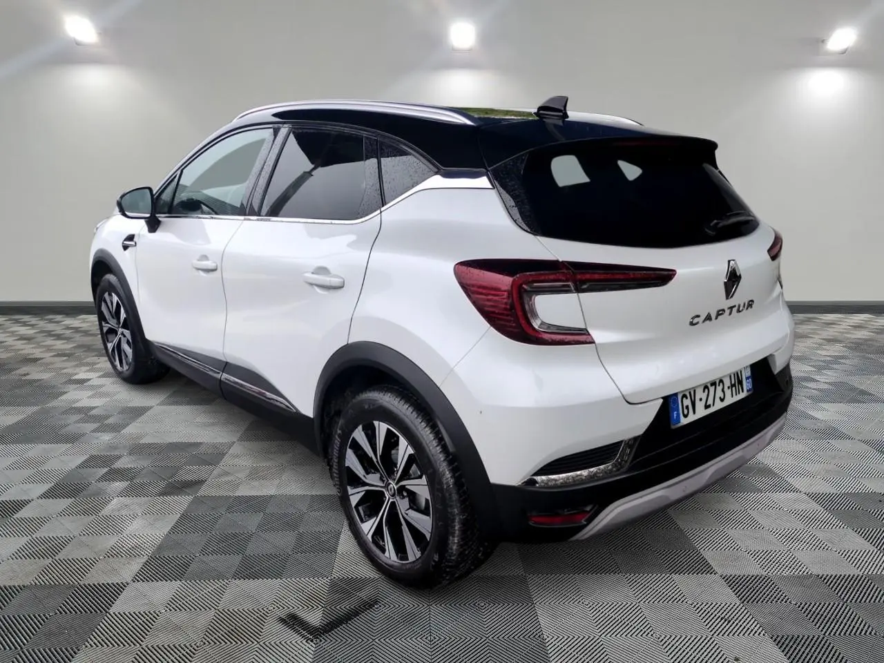 Vue 3/4 arrière droite d'un Renault Captur blanc avec toit noir et jantes alliage 18 pouces Pasadena.